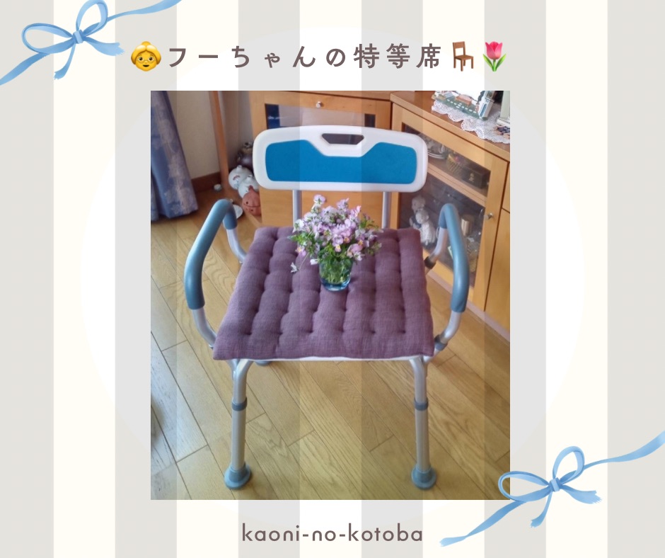 母フーちゃんが、介護用のシャワーチェアに座布団を敷き、お花を飾って自分を癒やす特等席にした写真。
